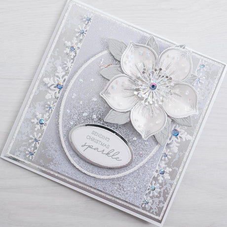 Learn how to make your own white and silver floral Christmas Card at home with this quick and easy Christmas Rose card tutorial from Chloes Creative Cards.
